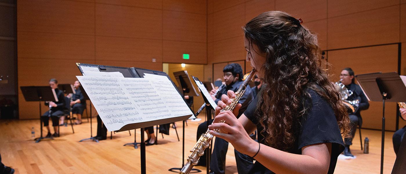 Close up of clarinet player among other musicians on stage practicing for a performance