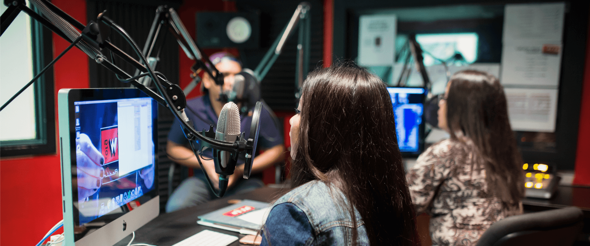 Male student filming on the back, while a female student interviews another female student for UIWtv